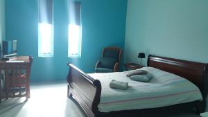 威廉斯塔德库拉索旅馆的一间卧室拥有蓝色的墙壁,配有一张带两个枕头的床