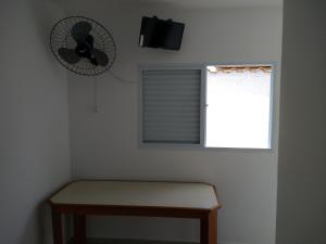 瓜鲁雅Consulado Praia Hotel的客房设有风扇、长凳和窗户。