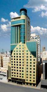 麦纳麦Frsan Palace Hotel的一座高大的建筑,在城市里装有玻璃窗