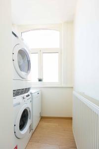 伊普尔Queen Astrid的洗衣房配有洗衣机和窗户