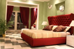 诺托玛丽娜Central Rooms的一间卧室配有一张红色大床和红色床头板