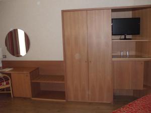 巴列塔尼科泰尔巴列塔酒店的客房设有一个木柜,其中配有电视