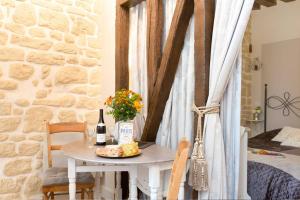 巴黎Le Diamant En Isle的一张桌子,上面放着一瓶葡萄酒和一盘奶酪