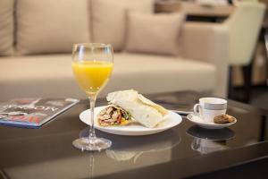 贝尔格莱德共和国广场多米尼克时尚豪华旅馆的一杯橙汁和一盘食物及饮料
