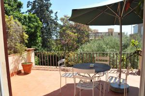 巴塞罗那蒂比达博公寓酒店的庭院配有桌椅和遮阳伞。