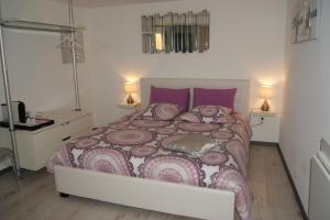 卡斯泰尔诺勒莱B&B Villa Castelnau Montpellier的一间卧室配有一张带紫色枕头的大床