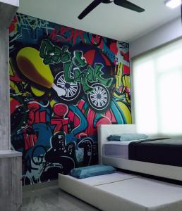 怡保怡保壮丽公寓的一间卧室,墙上涂有涂鸦