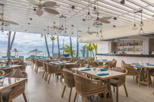 长滩岛赫纳恩尊贵海滩度假酒店的一间带桌椅的海景餐厅