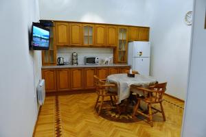 巴库巴库之家旅舍的厨房配有桌椅和电视。