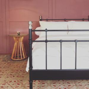 三宝垄Spiegel Home Studio的一张黑色的床,配有白色枕头和边桌
