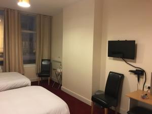 卡迪夫ML旅馆的酒店客房设有一张床和墙上的电视