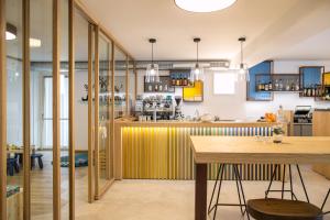 帕苏德尔托纳莱Alpencolor Hotel Tonale的厨房设有黄色的柜台和桌子