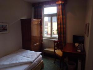 维斯洛赫弗雷霍夫旅馆的一间卧室配有一张床、一张书桌和一个窗户。