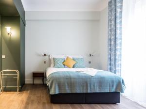 巴黎1er Etage SoPi-Montmartre的一间卧室配有蓝色和黄色枕头的床