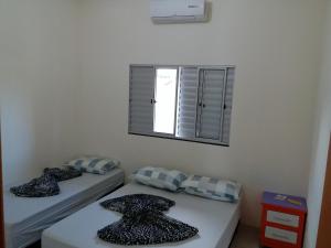 博尼图Atlantico Residencial的带窗户的客房内设有两张单人床。