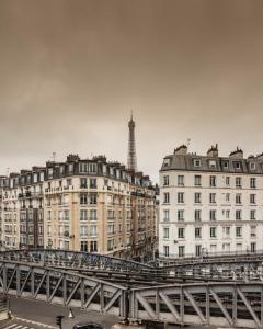 巴黎埃菲尔小卢浮宫酒店的一座桥,河上有建筑物和塔
