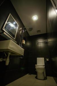 怡保好莱坞酒店的一间带卫生间和水槽的浴室以及一台电视。