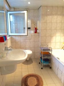 诺伊斯Individuell Wohnen Loft-Charakter im Innenhof的浴室配有盥洗盆、卫生间和浴缸。