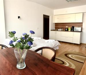 克卢日-纳波卡佐尔络公寓式酒店的木桌边的蓝色花瓶