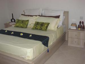 格兰高伯Villa Pupunu 1的一间卧室配有一张带绿色枕头的大床