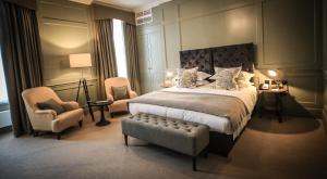 赛伦塞斯特金斯海德酒店的一间卧室配有一张大床和两把椅子
