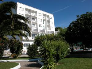 格罗韦托瑞斯酒店的一座白色的建筑,前面有棕榈树