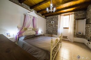 斯波莱托Appartamento di Lucrezia的一间卧室配有一张大床和紫色窗帘