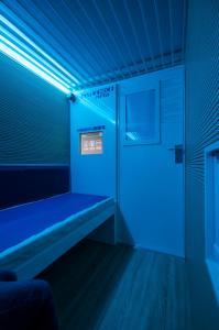 FernoResting Pods - -ZZZleepandGo MXP Airport的一间蓝色的房间,在一扇门的房间里设有长凳