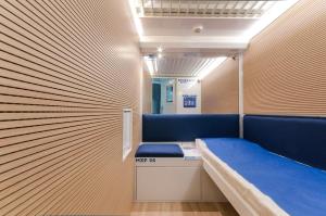 FernoResting Pods - -ZZZleepandGo MXP Airport的一间设有蓝色长椅和墙壁的房间
