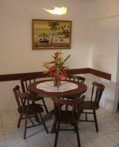 累西腓爱丽丝特诺里奥公寓的餐桌和椅子,上面有植物