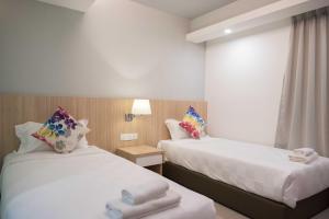 卢穆特晨星酒店@红土坎海滨的两张位于酒店客房的床,配有毛巾