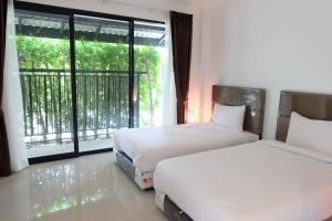 Kamphaeng Saen坎贝盛米图辛姆特拉酒店的一间卧室设有两张床和大窗户