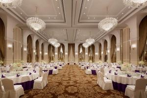 安吉县银润锦江城堡酒店的宴会厅配有白色的桌椅和吊灯