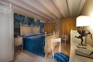 加瓦尔多坎比别墅精品住宿加早餐旅馆的一间卧室配有一张带蓝色棉被的床