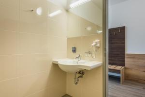 LoosdorfSleepin Premium Motel Loosdorf的一间带水槽和镜子的浴室