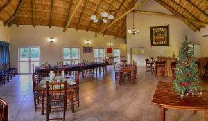 MasisiAwelani Lodge的一间用餐室,配有圣诞树和桌椅