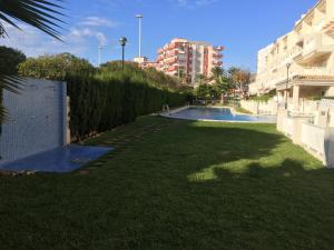哈维亚Apartment Las Dunas的一座带游泳池的院子,毗邻一座建筑