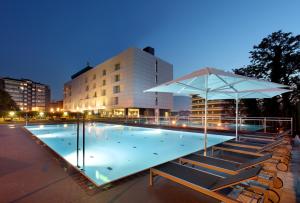 毕尔巴鄂毕尔巴鄂西方酒店的一个带椅子和遮阳伞的游泳池