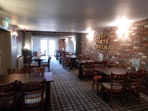 马基特雷森白天鹅酒店的一间设有桌椅的用餐室和砖墙