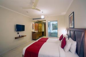 瓦斯科达伽马HQ酒店的一间卧室配有一张带红色和白色枕头的大床