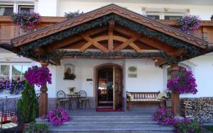 塞尔瓦迪加尔代纳山谷Hotel Garni Concordia - Dolomites Home的凉亭配有桌椅和鲜花
