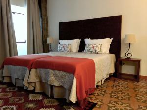 古勒冈卡萨格勒加 赛车德哈比塔宾馆的一间卧室配有一张带红色毯子的大床