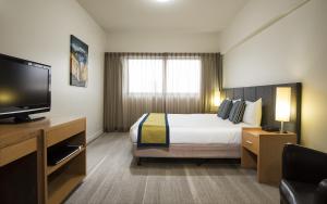 麦凯Aligned Corporate Residences Mackay的配有一张床和一台平面电视的酒店客房