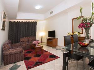 马斯喀特萨费酒店套房的客厅配有沙发和桌子