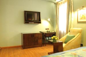 班加罗尔juSTa MG Road的配有床、电视和椅子的房间