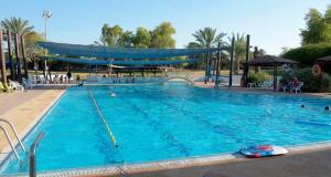 H̱aẕeva斯维里穆巴米德巴尔沙漠路线客栈的一个大型蓝色游泳池,里面有人