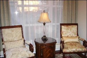 雷克雅未克凤凰酒店的一间设有两把椅子、一张桌子和一盏灯的房间