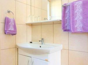 科洛塞普Sandy Beach Apartments的一间带水槽和紫色毛巾的浴室