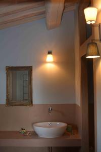 马萨马里蒂马Le Moraiole的浴室设有水槽、镜子和灯