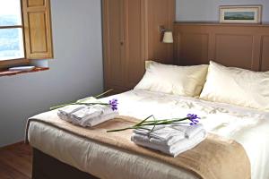 马萨马里蒂马Le Moraiole的床上有毛巾和紫色鲜花